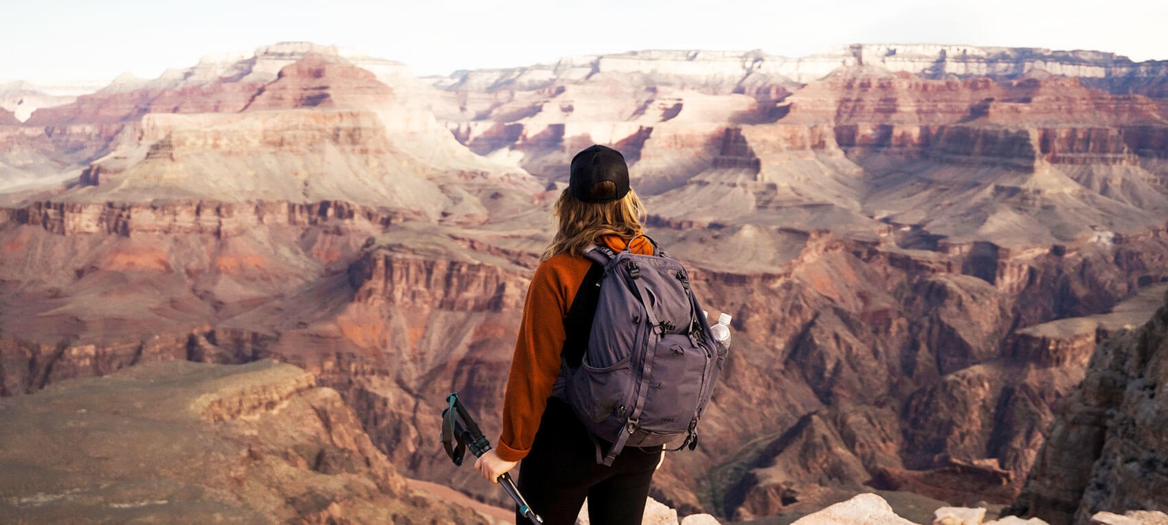 Hiker looking out over the expanse of the grand canyon, with image cropped and optimized.